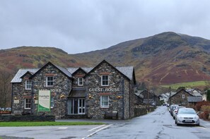 A stone building labeled "GUEST HOUSE" with a sign for "Fairlight Cafe" on the left. - Fairlight Guesthouse (Penrith)