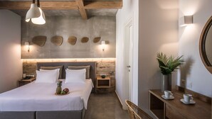 A modern bedroom with a large bed, wooden headboard, bedside tables, a wall-mounted light, and a small plant. - Enorme Maya Beach - Adults Only (Hersonissos)