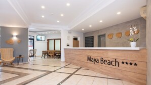 A reception area with a wooden counter labeled "Maya Beach" and a check-in desk. - Enorme Maya Beach - Adults Only (Hersonissos)