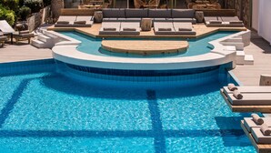 A pool area with a circular hot tub, lounge chairs, and a wooden deck. - Enorme Maya Beach - Adults Only (Hersonissos)