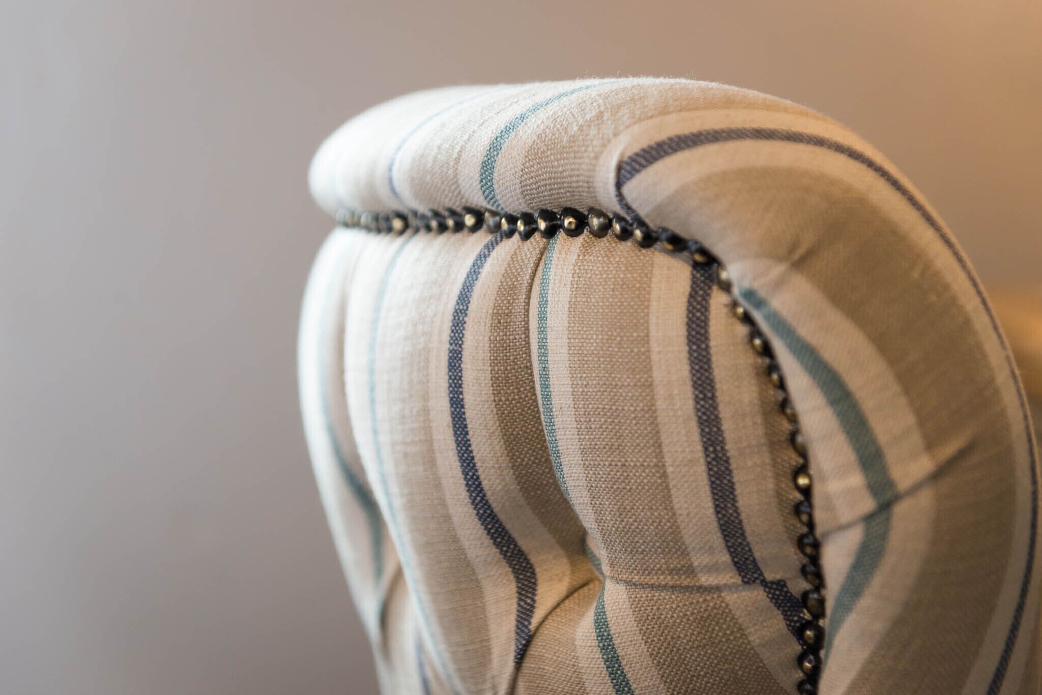A close-up of a fabric with a striped pattern and a beaded trim.