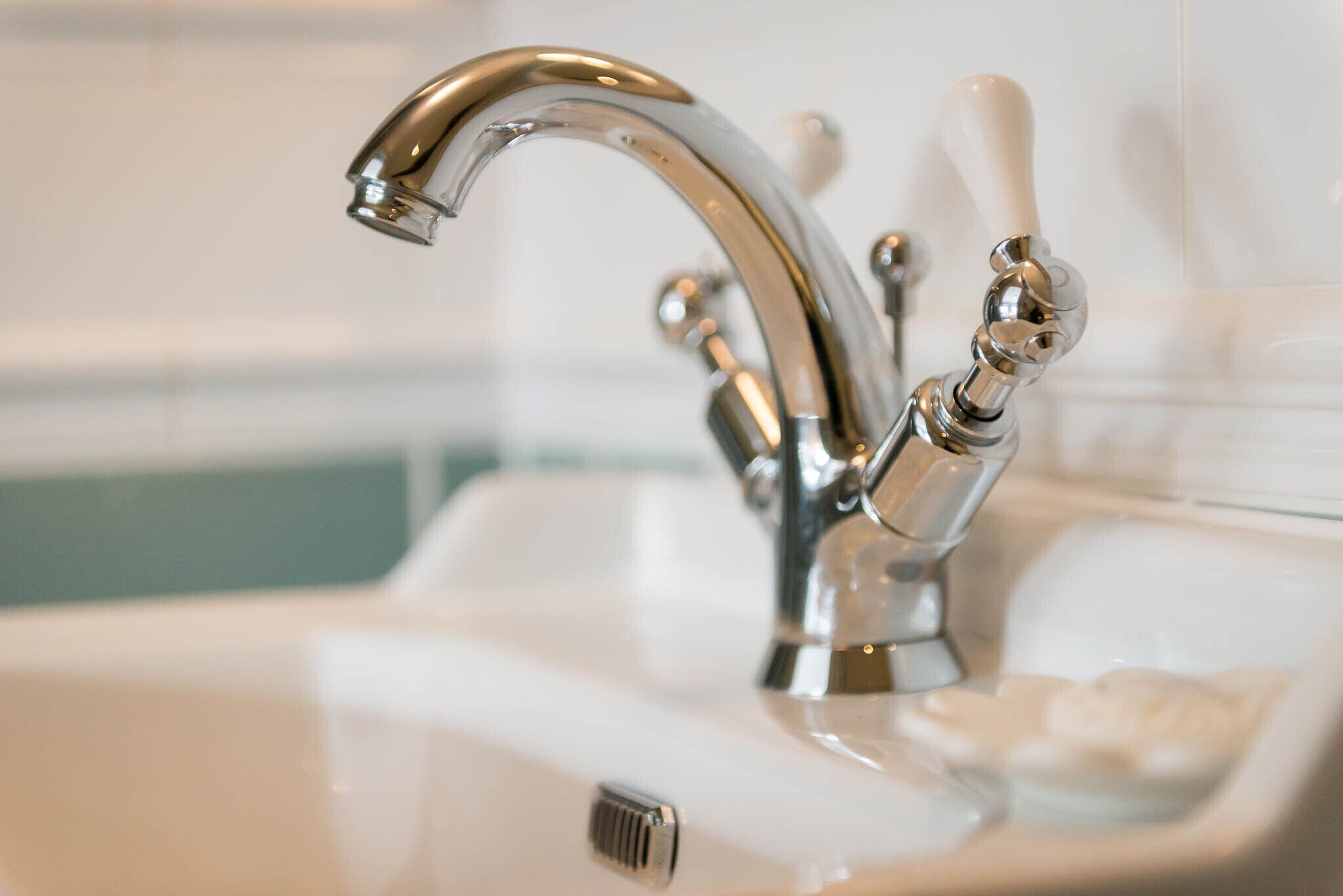 A bathroom sink with a chrome faucet and soap dish.