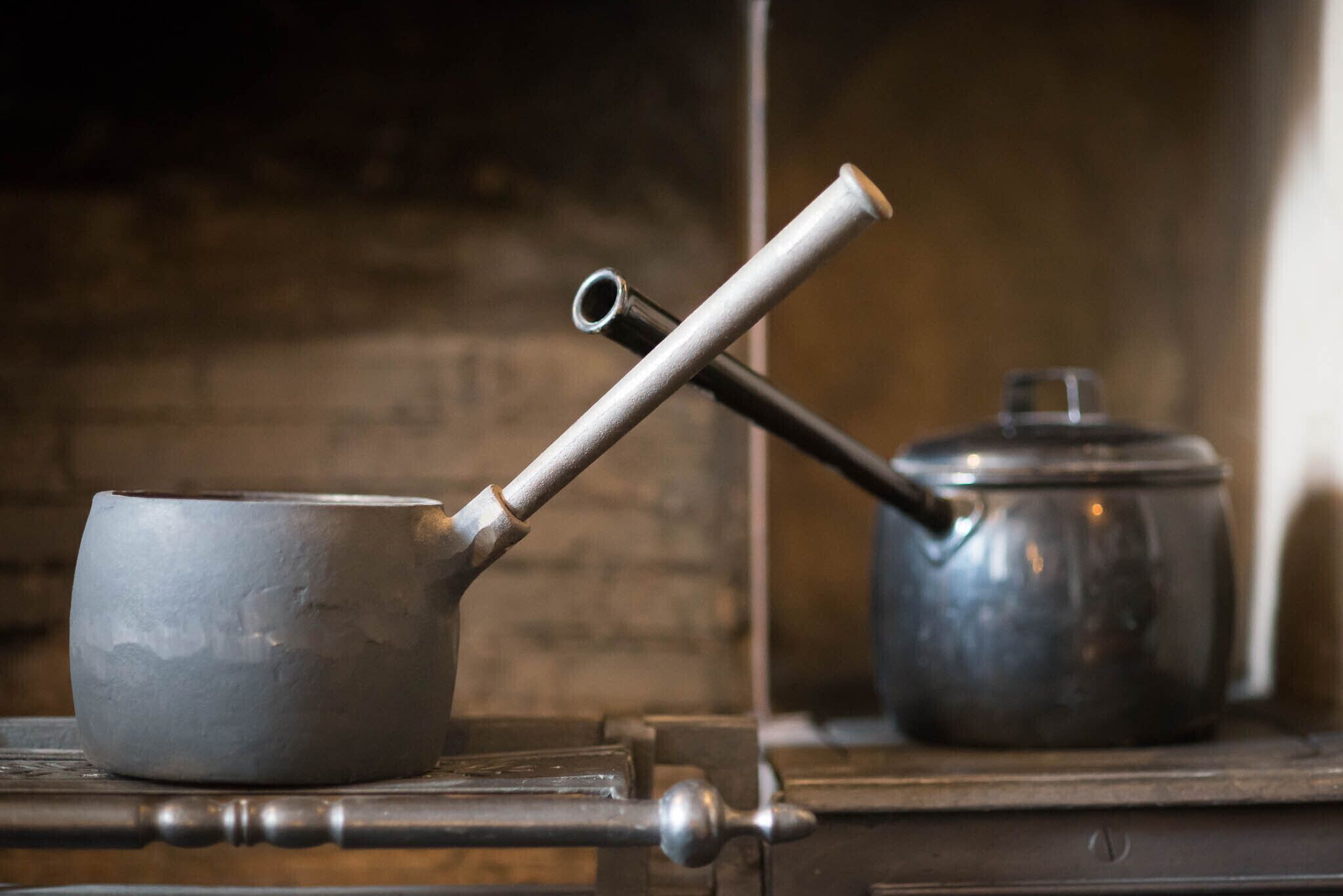 Una tetera metálica y una olla sobre la estufa.
