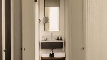 A bathroom with a mirror, sink, and towel rack.