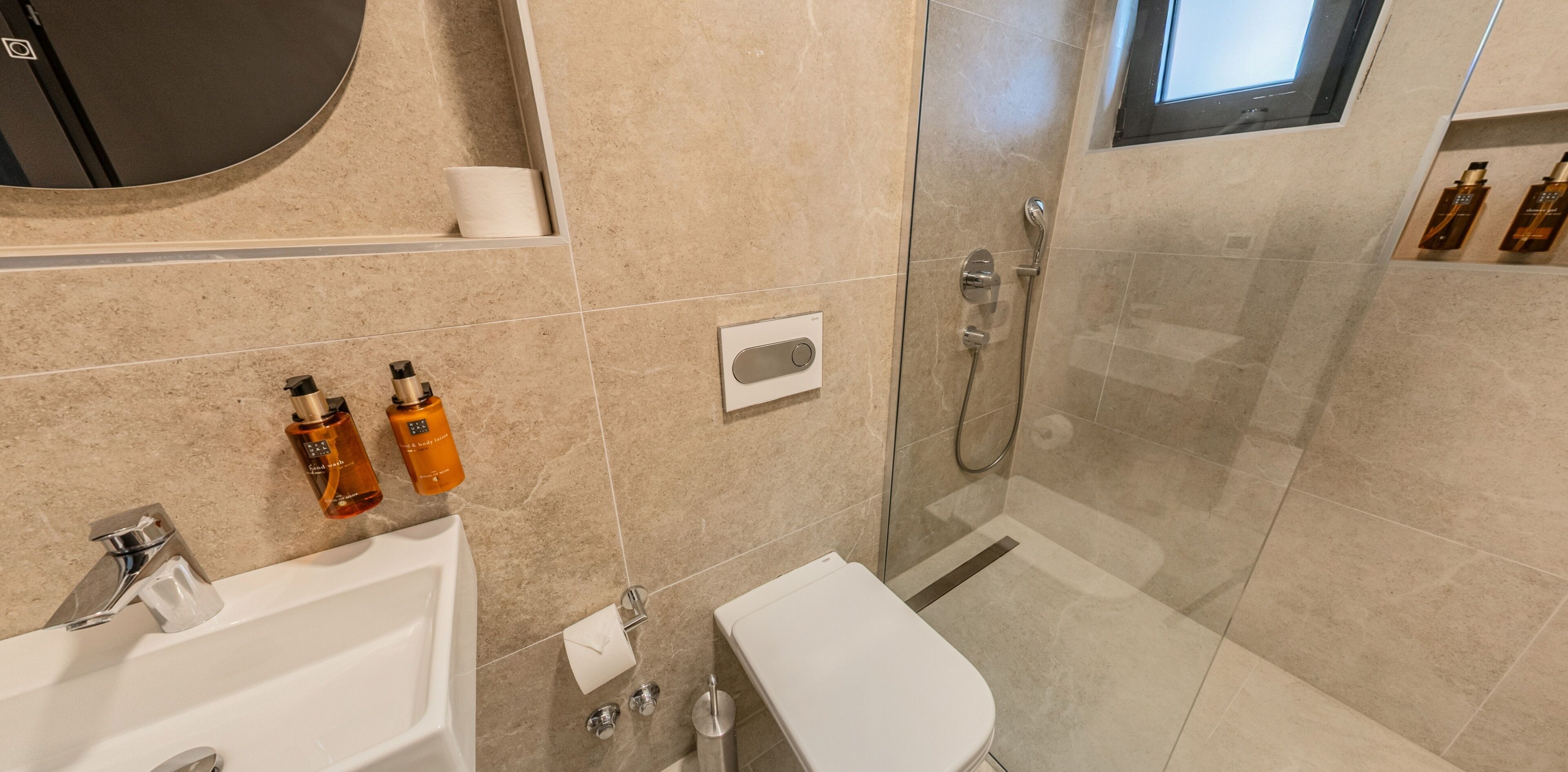 A modern bathroom with a sink, toilet, and shower.