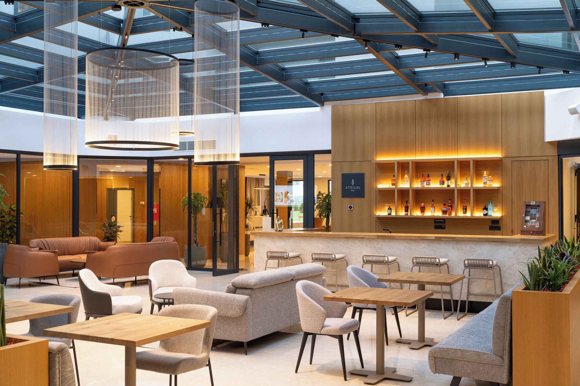 A modern interior with a bar area, seating arrangements, and a glass ceiling.