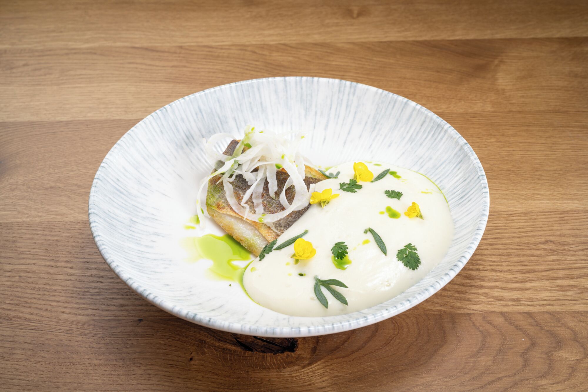 Un plato de cerámica blanca con un alimento sobre una mesa de madera.