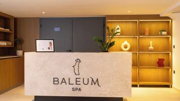 Een receptiebalie met een bord waarop 'BALEUM SPA' staat en een inlijsting met een certificaat.