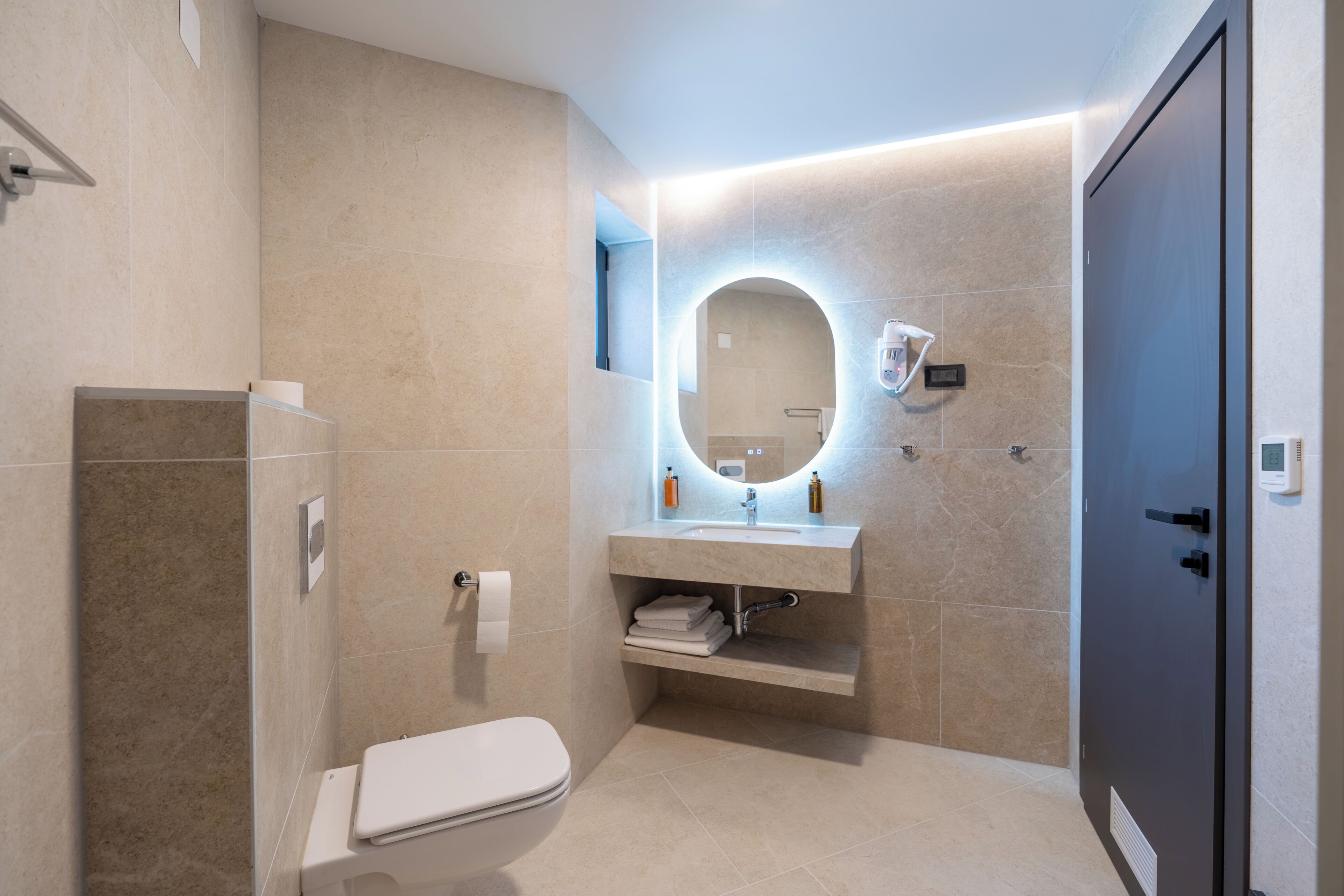 Un baño moderno con inodoro, lavamanos y ducha.