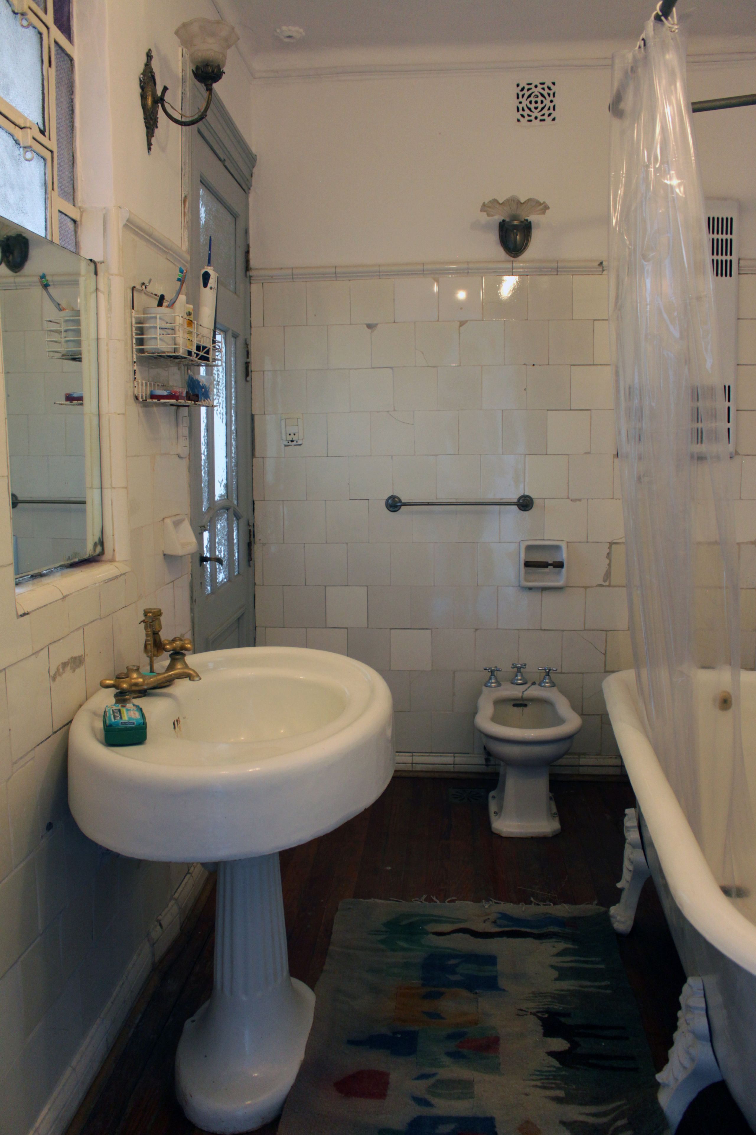 A bathroom with a pedestal sink, a bidet, and a bathtub.