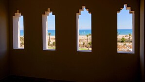 Quatre fenêtres en arc donnant sur la plage.