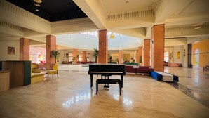 Un hall d’entrée spacieux, agrémenté d’un magnifique piano à queue, doté de hauts plafonds et arborant un design moderne.
