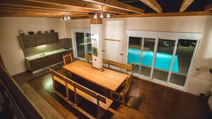 Cocina moderna con comedor y vista a una piscina al aire libre.