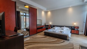 Una habitación de hotel moderna con una cama grande, un televisor, un escritorio y un espejo.