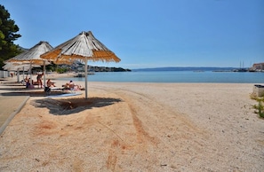 A beach with thatched umbrellas and a clear view of the sea. - Pansion Epetium (Split)