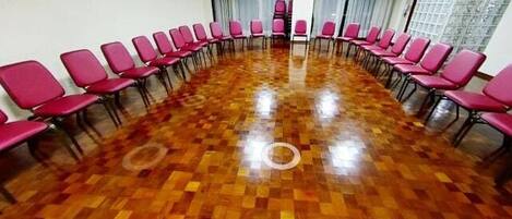 A conference room with a long table and rows of chairs.