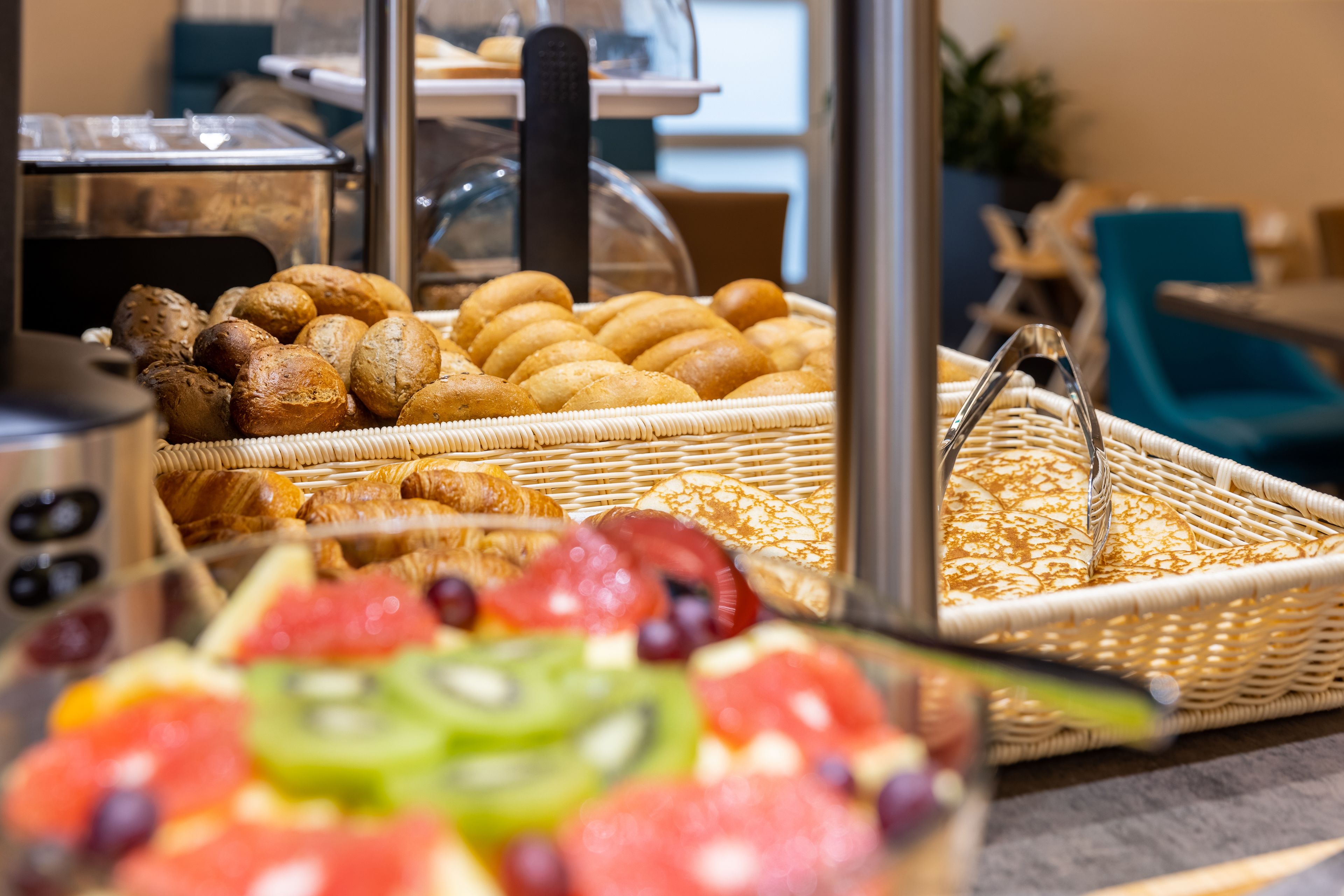A buffet with various baked goods and fresh fruits.