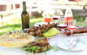 Enjoy a casual outdoor dining experience with grilled meats, flatbread, and refreshing drinks.