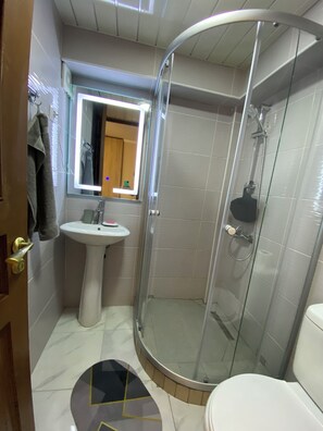Habitación doble estándar, 1 cama matrimonial | Baño | Regadera, amenidades de baño gratuitas, pantuflas
