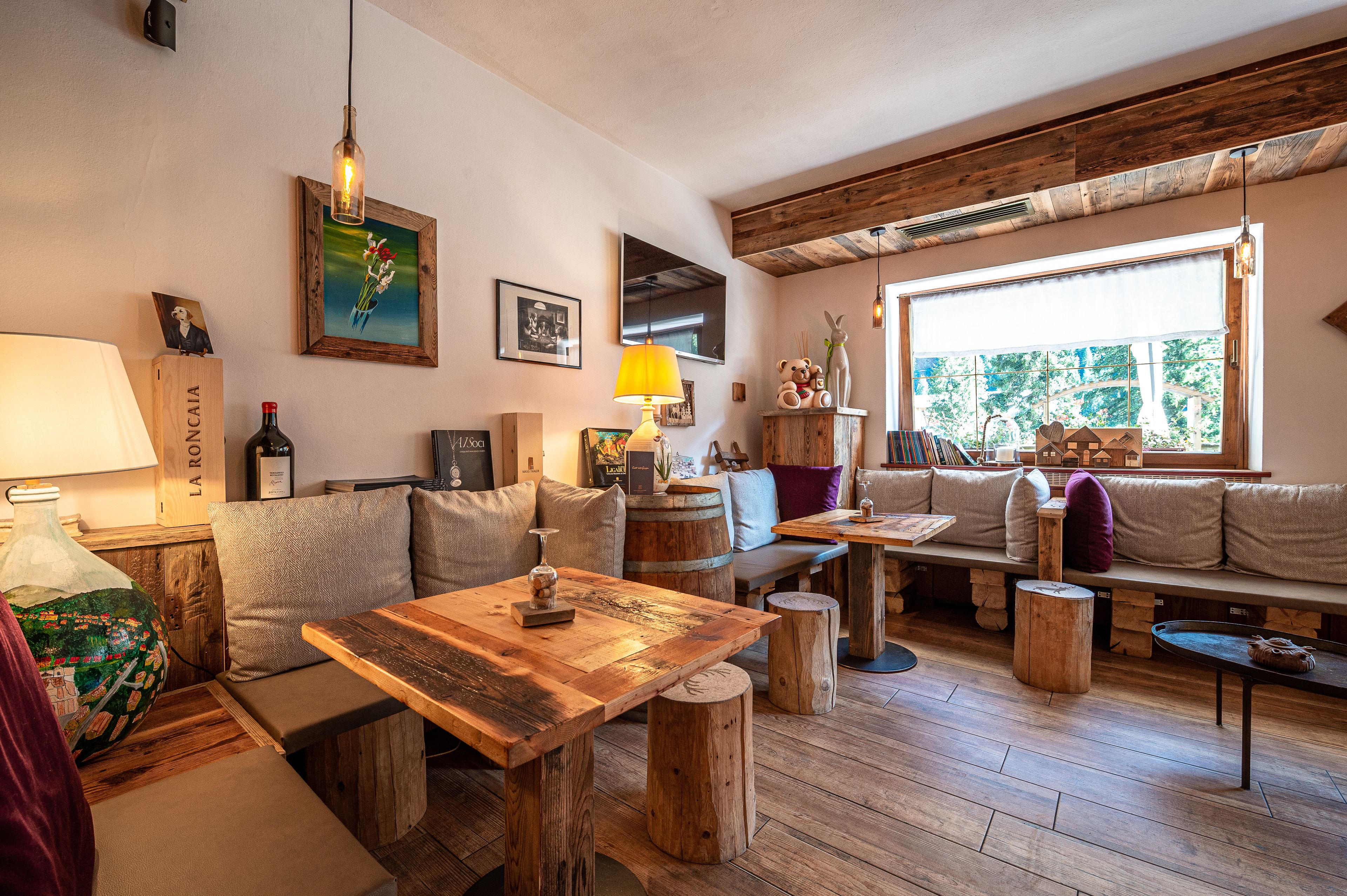 Un interior acogedor con muebles de madera, un ventanal grande y un techo rústico.
