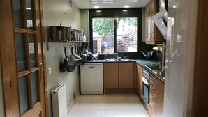 Una cocina moderna con armarios de madera, lavavajillas integrado y ventana con vistas al exterior.