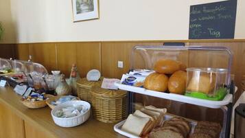 A breakfast buffet with various food items and a chalkboard sign.