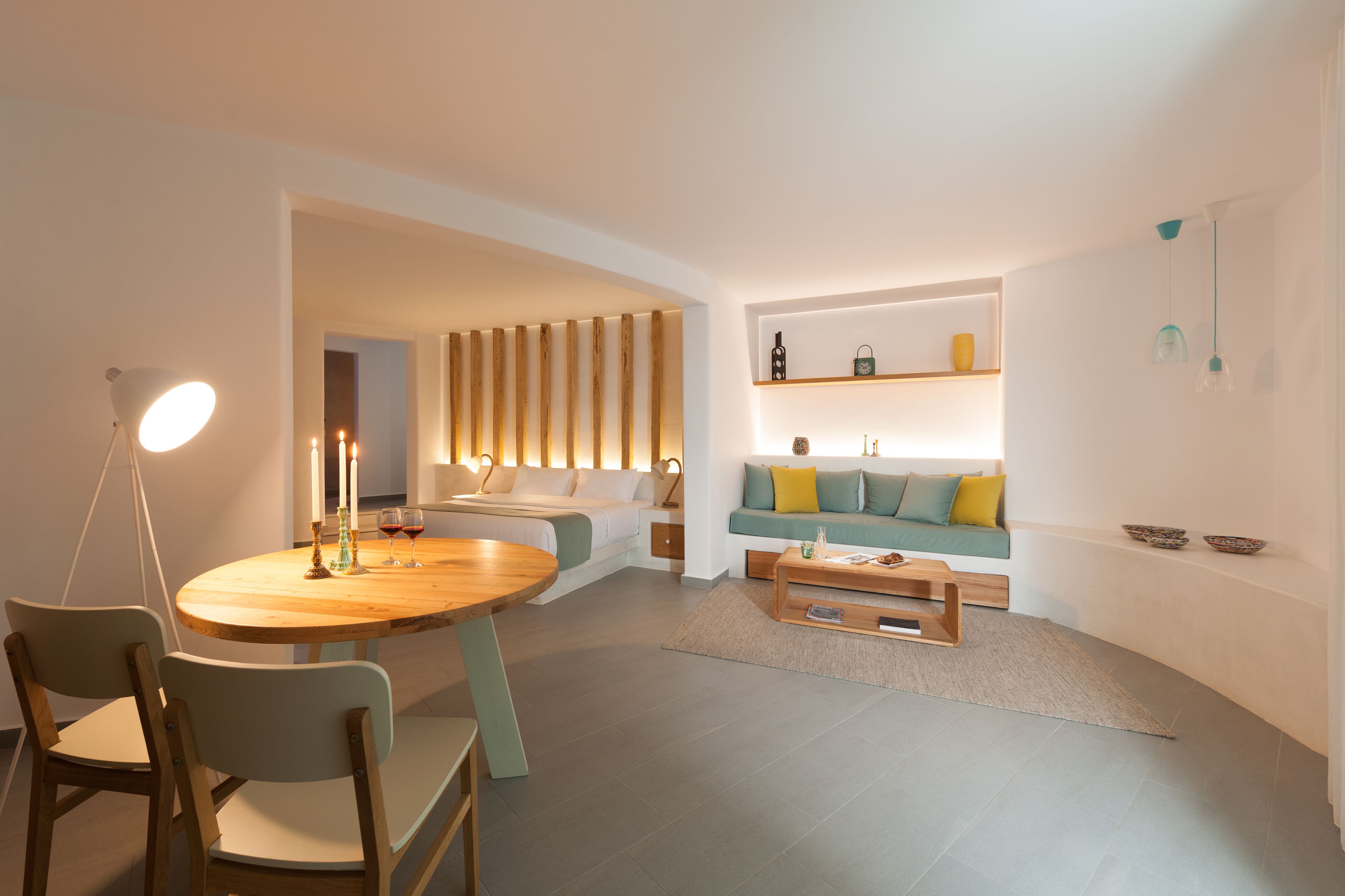 Un salon moderne avec une table de salle à manger ronde en bois, un canapé et une table basse.
