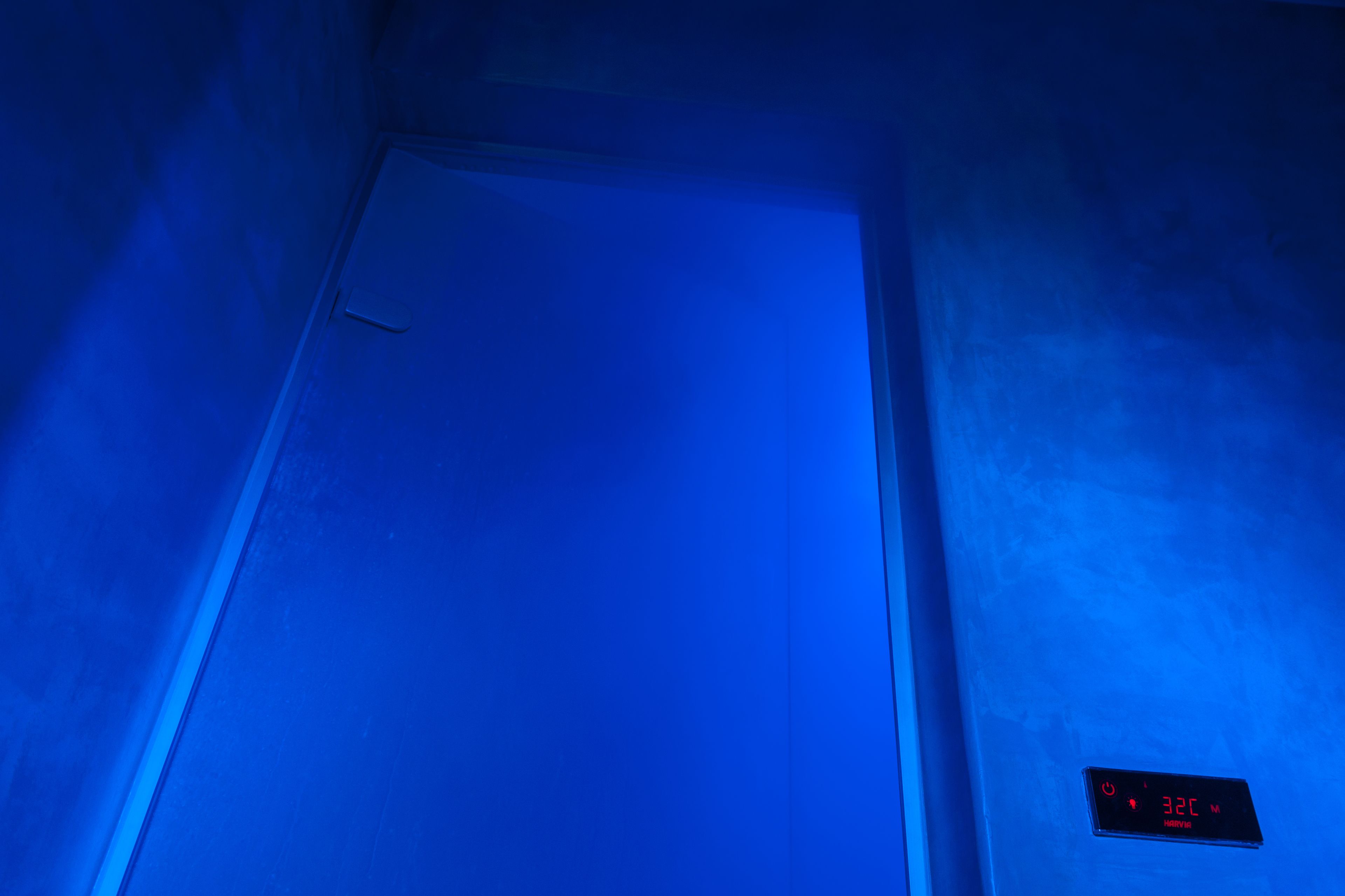 Una habitación con un termostato digital que muestra 32 grados Celsius.