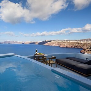 Zona junto a la piscina con vista al mar y acantilados.