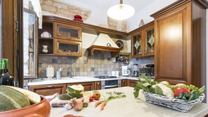 Een keuken met houten kastjes, een betegelde achterwand en diverse keukenapparaten.