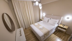 Et moderne hotelværelse med en stor seng, sengeborde, et spejl og en lampe i loftet.