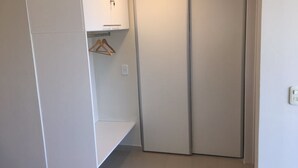 A room with a wardrobe, a hanging rack, and a light switch. - Bulnes & Cabrera (Buenos Aires)