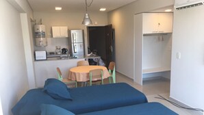 A compact room with two beds, a small kitchen area, and a dining table. - Bulnes & Cabrera (Buenos Aires)