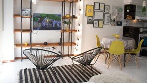 A modern living room with a TV, a 'HOME' sign, a 'WELCOME' sign, and a 'NO BAD VIBES' sign. - Cabrera & Gascon (Buenos Aires)