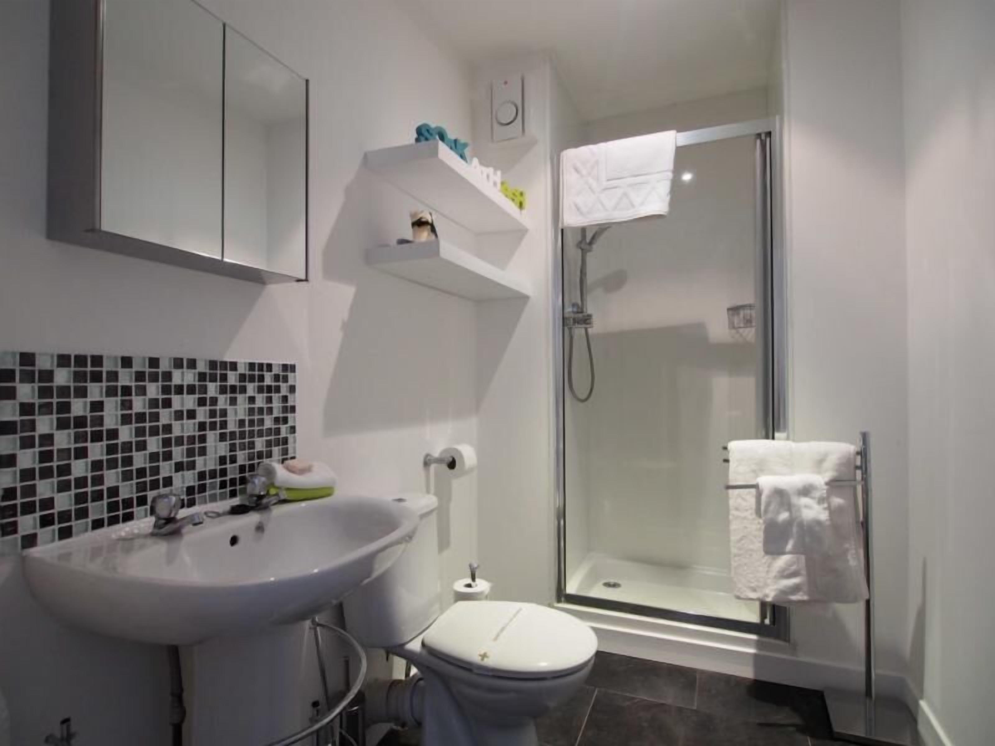 Ein Badezimmer mit Waschbecken, Toilette und einer Duschkabine.