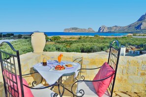 A table set outdoors with a view of the sea and mountains. - Koukis House With Sea View (Kissamos)