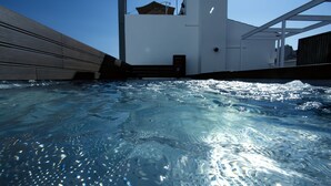 A swimming pool with clear water and a view of the building's exterior. - Terreno Suites (Palma de Mallorca)