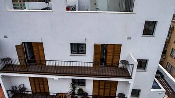 Un immeuble à plusieurs étages, doté de balcons et de fenêtres, avec une grue de construction visible à l’arrière-plan.