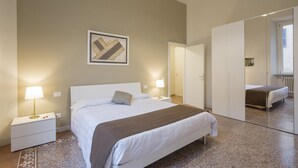 Un dormitorio con cama, mesitas de noche, un espejo y una obra de arte colgada en la pared.