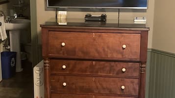 A wooden dresser with drawers and a flat-screen TV on top.