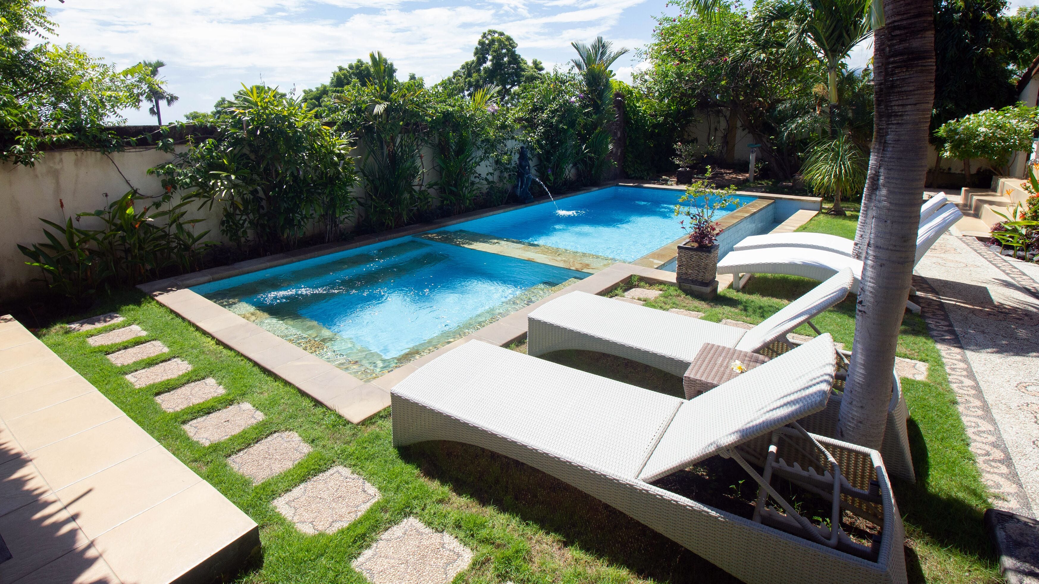 Una piscina al aire libre, sillones reclinables de piscina