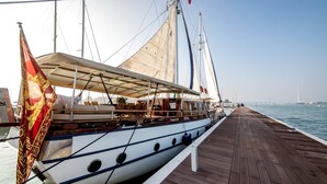 A wooden pier with a sailboat docked at the end. - Venezia Boat San Marco (Venice)