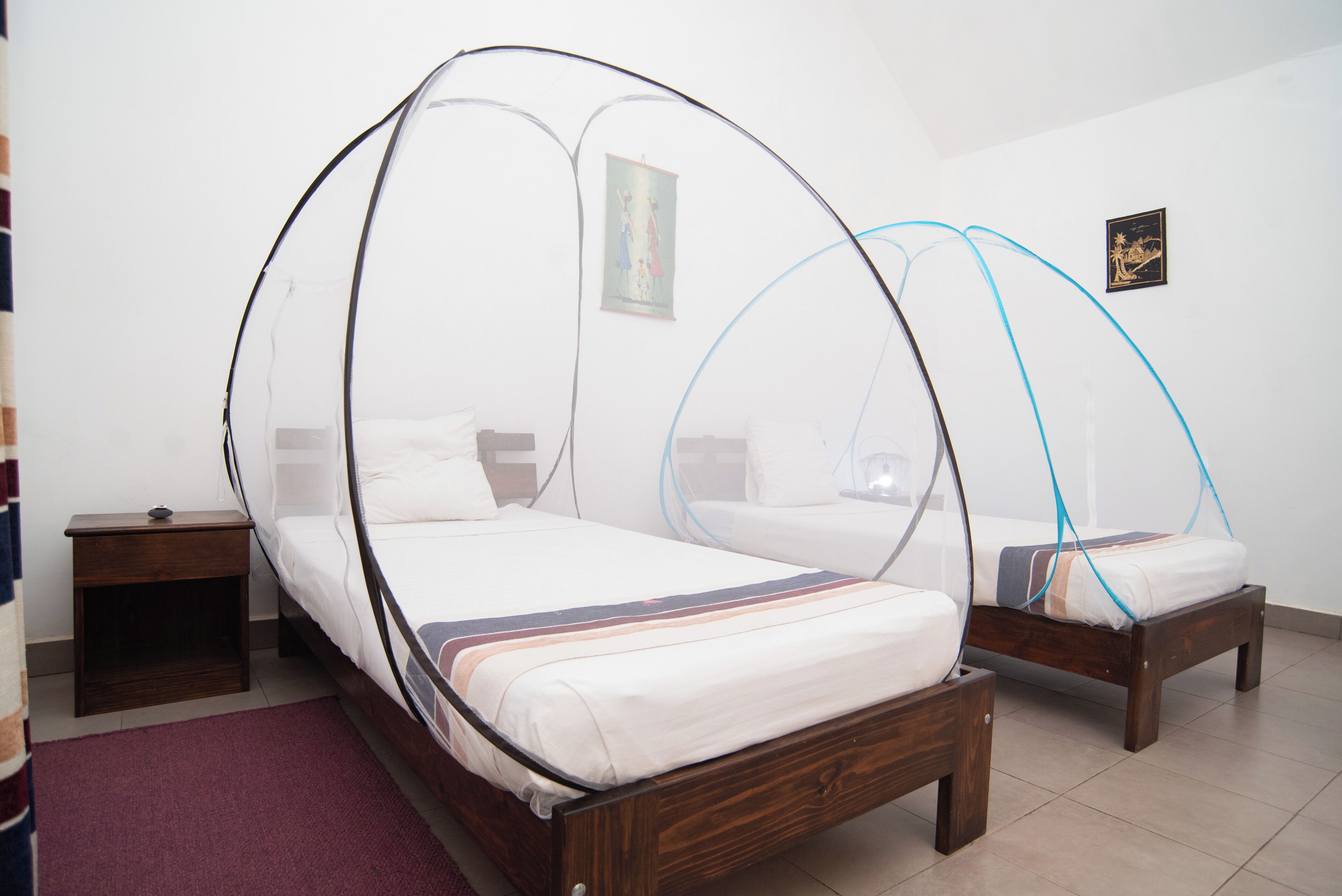 A room with two wooden beds, each with a canopy bed frame.