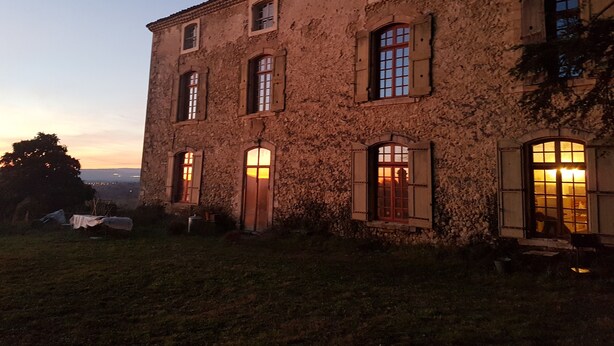 A rustic building with multiple windows and a door, surrounded by a grassy area. - Bastide de l'Adrech (Manosque)