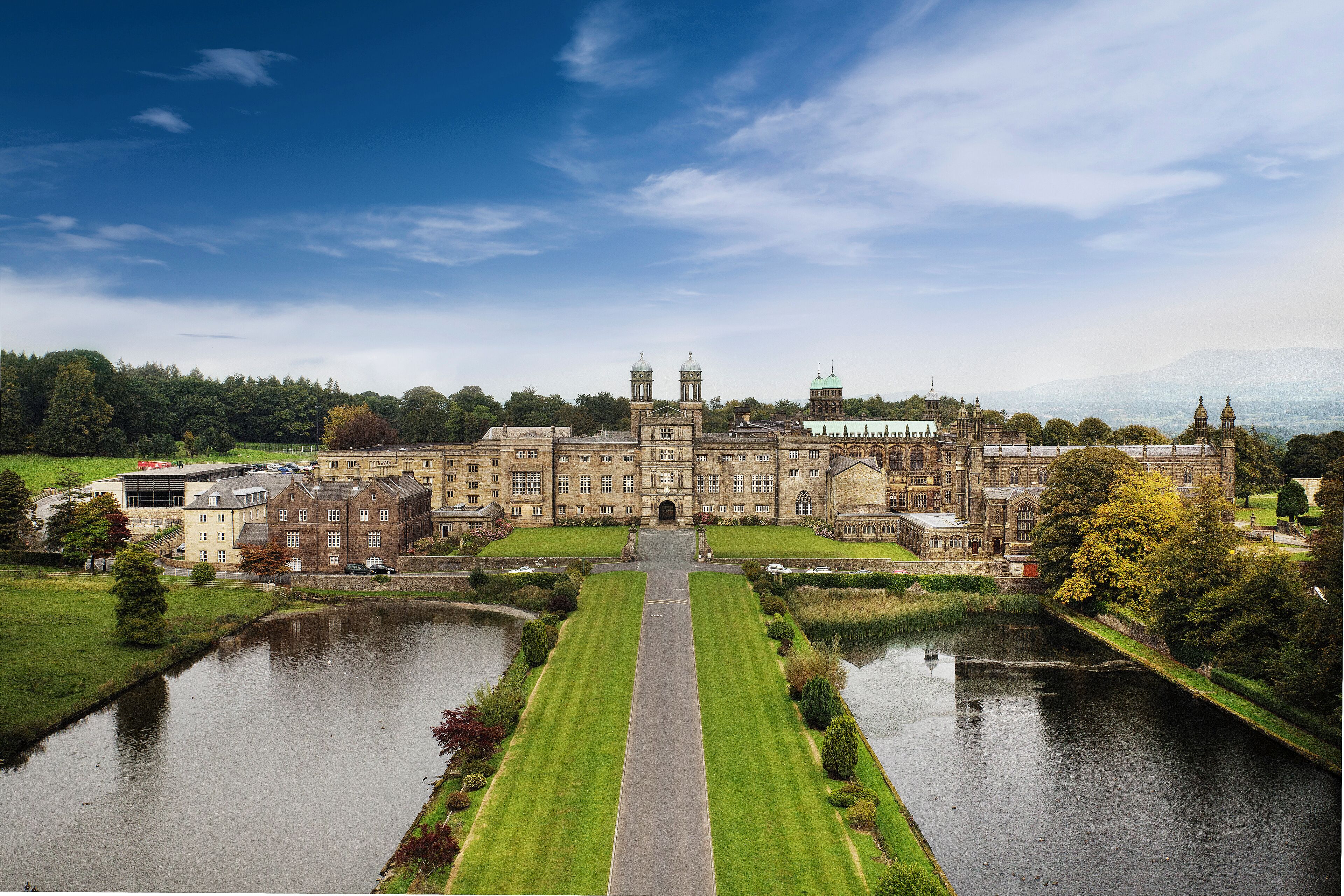 A large, historic building with a symmetrical facade, a central entrance, and a surrounding moat.