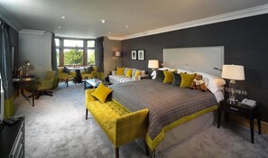 A modern hotel room with a large bed, a desk, and a seating area. - Northcote (Blackburn)