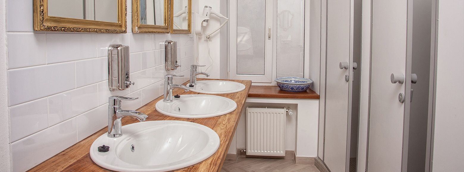 A modern bathroom with two sinks, a mirror, and a radiator.