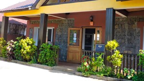A building with a stone facade, a wooden door, and a signboard. - Hotel H1 Manakara SCHM (Manakara)