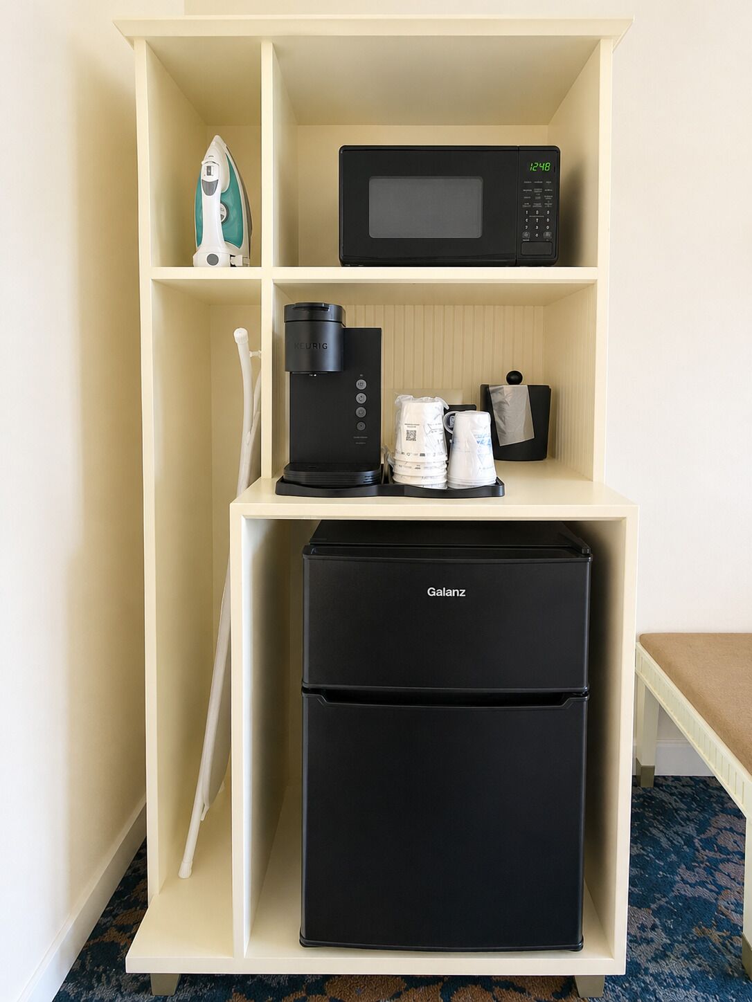 Eine Küchenzeile mit Mikrowelle, Kaffeemaschine und Kühlschrank.