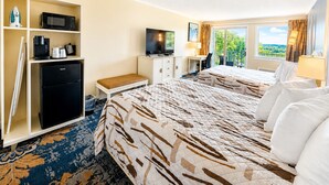 A hotel room with a bed, a desk, a television, a minibar, and a view of the outdoors. - Cod Cove Inn, BW Signature Collection (Edgecomb)